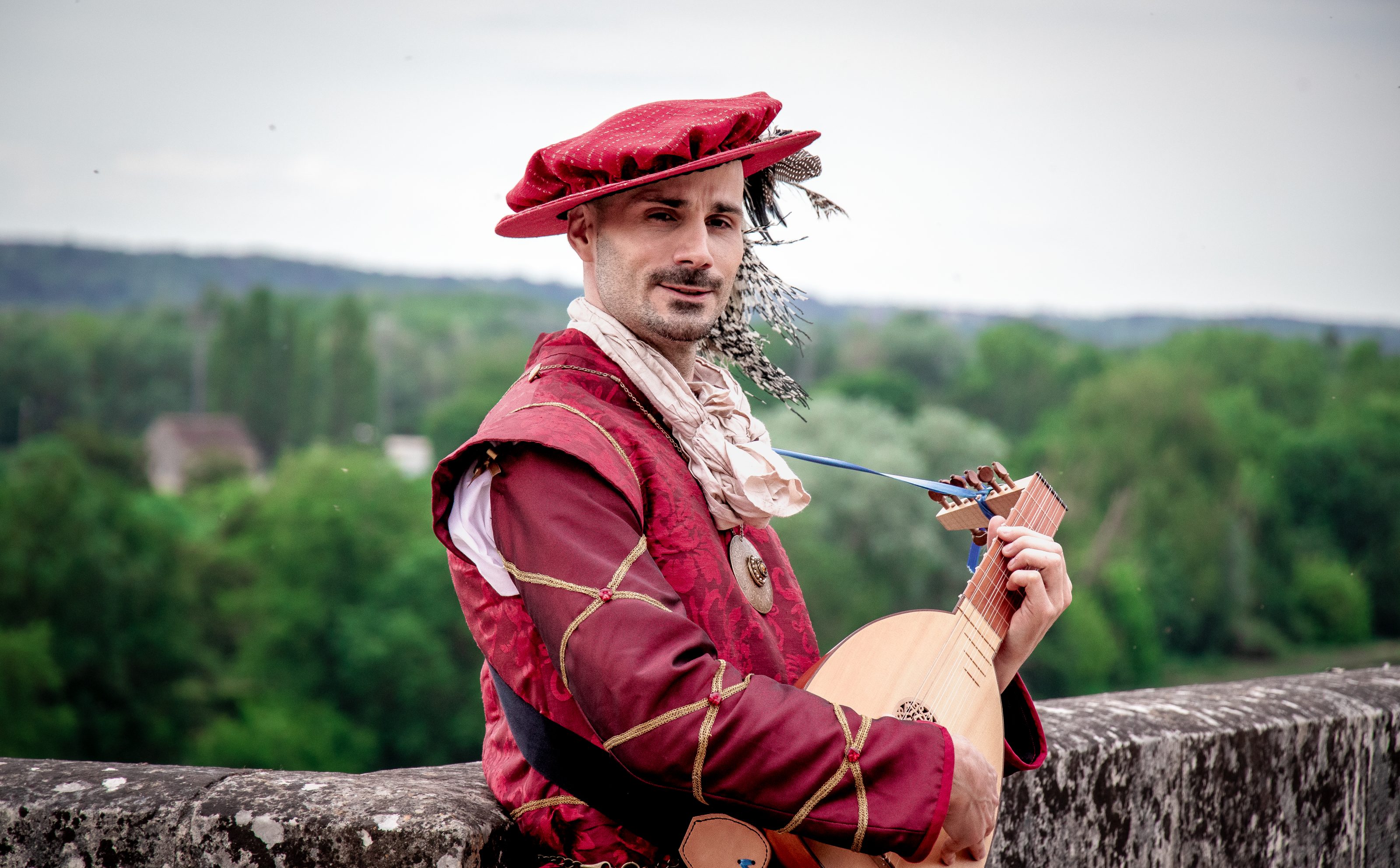 Tonton en costume joue d’un instrument médiéval.