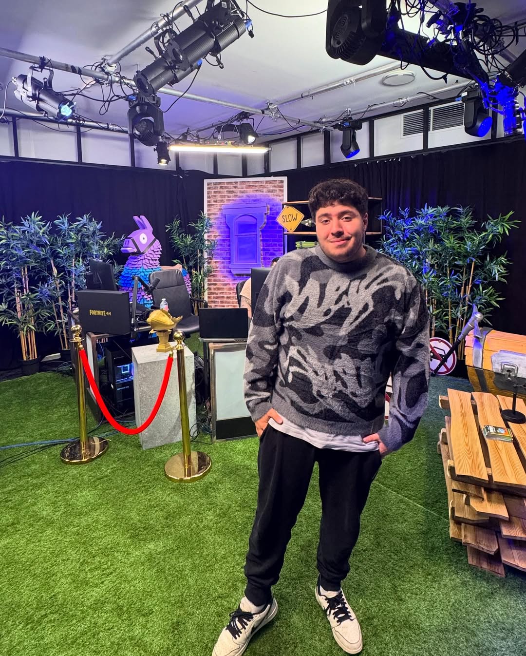 Jinskow lors d’un évènement Fortnite, posé devant la scène décorée de lamas et écrans gaming