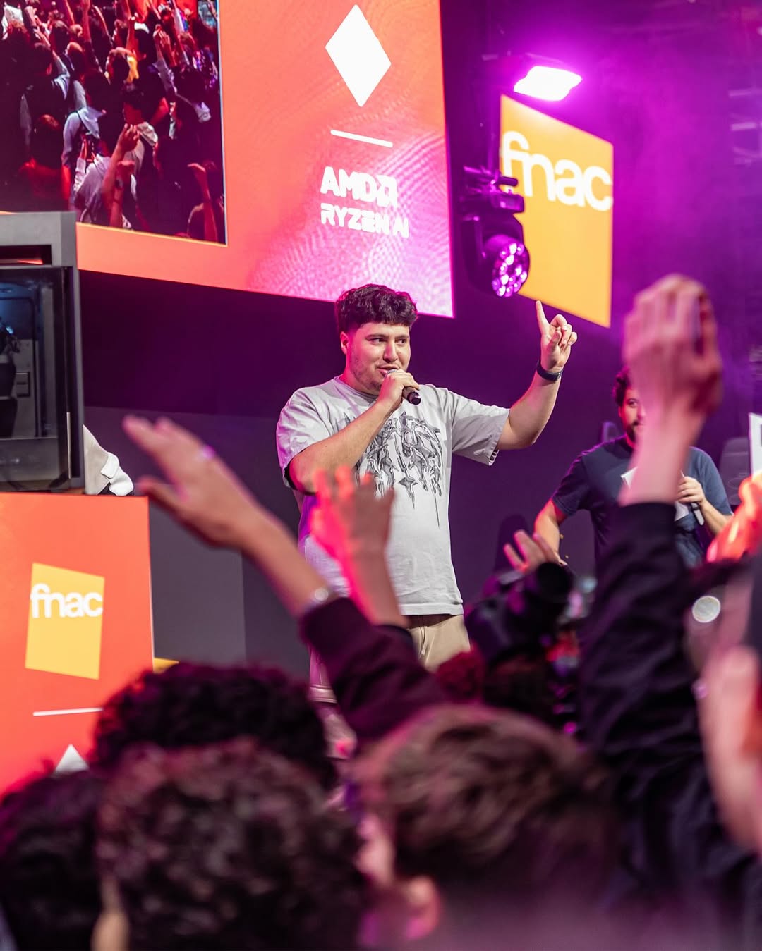 Jinskow sur scène avec un micro à la main devant la foule, lors du show Fnac x AMD à la Paris Games Week